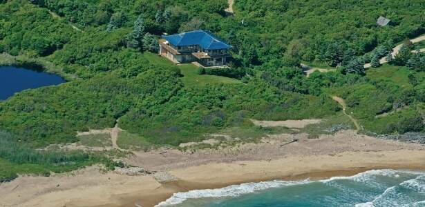 Em um terreno de 14 hectares no alto de uma falésia, a residência com arquitetura moderna tem pisos de mármore e uma lagoa privada. (Foto: Reprodução)