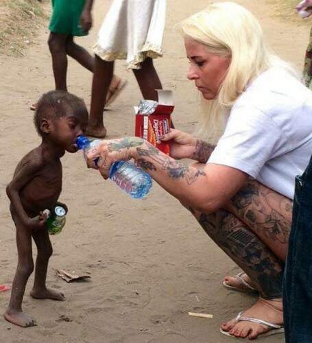 Anja Ringgren Lovén oferece água e biscoitos a Hope ao resgatar o menino das ruas, na Nigéria