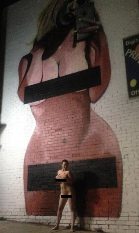 Mulher posa nua em frente ao mural de Kim. (Foto: Reprodução)