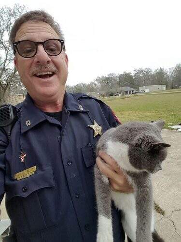 O policial com a gata Bella (foto: reprodução/Facebook).