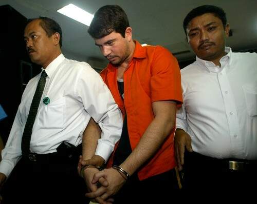 Rodrigo Gularte é escoltado pela policia em Jacarta, na Indonésia, por tentar transportar 6 quilos de cocaina em pranchas de surfe.