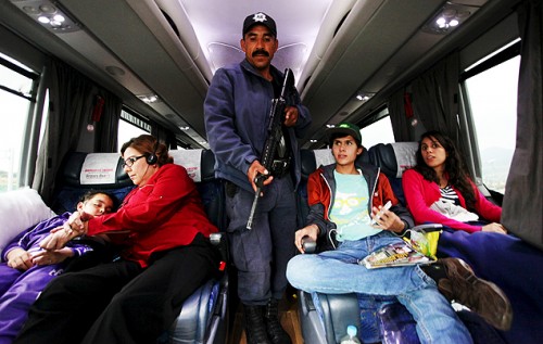 Policial faz inspeção em ônibus rodoviário em estrada de Michoacán, no México, em busca do traficante. (Foto: Reprodução)