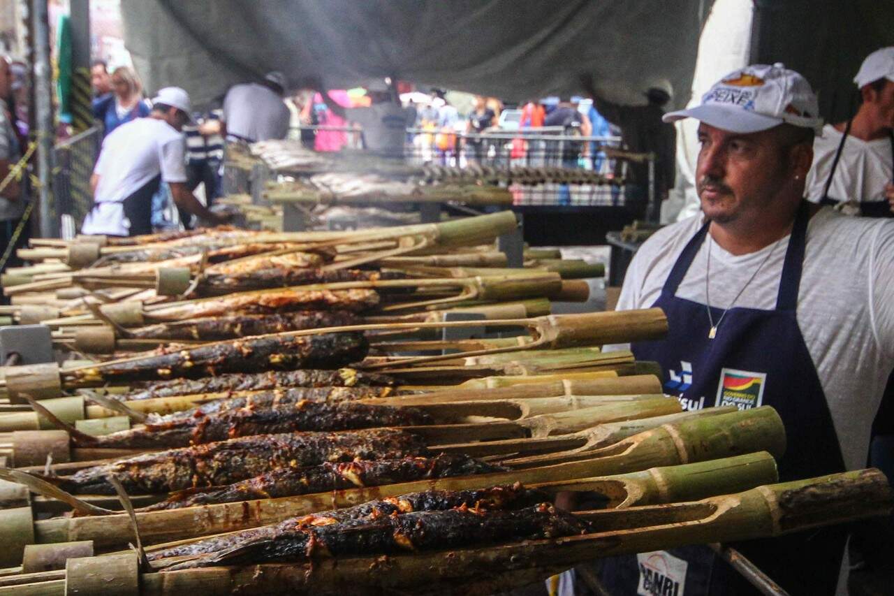 Peixe assado na taquara é tradicional na Feira do Peixe de Porto Alegre. (foto: Jackson Ciceri/ O Sul)