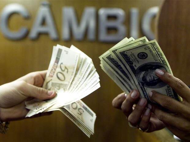 Notas de dólar e real em casa de câmbio
