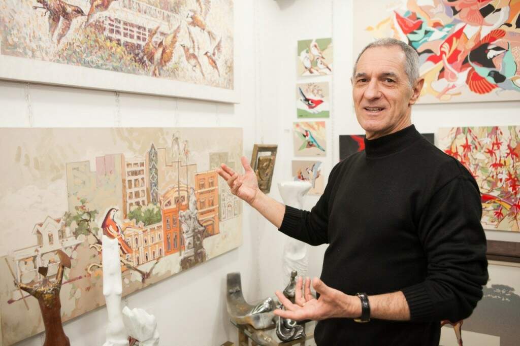 O artista Velcy Soutier ao lado das suas obras no vernissage. (Foto: Rodrigo Silveira/divulgação)