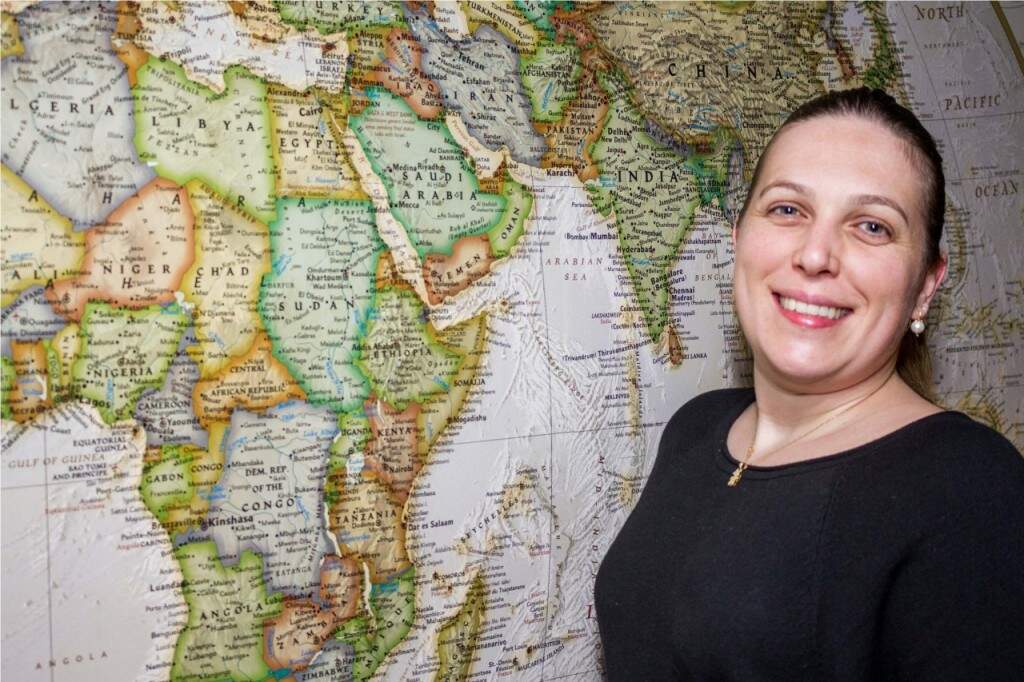 Carina Gaviraghi, ao lado do mapa mundi que compõe a decoração, é a hostess do simpático restaurante. (Foto: Pedro Antonio Heinrich/especial)