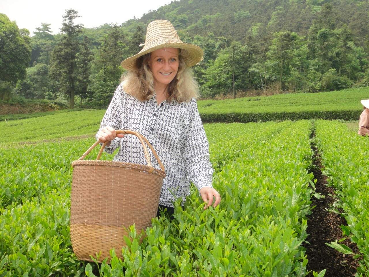 Carla Saueressig, em visita à China, escolhe ervas selecionadas da colheita. (Foto: divulgação) 