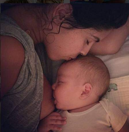 Bela posa amamentando o filho Nino.