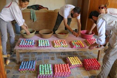 Voluntários preparam ovos pintados durante as celebrações após a missa de Páscoa na igreja Católica Caldea de Mar Gewargis (St George), que foi danificada, na cidade de Tel Esqof, no Iraque (Foto: Reprodução)