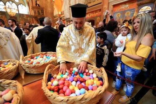 Padre libanês distribui ovos pintados durante celebração da Páscoa Ortodoxa Grega na Igreja de São Jorge em Beirute, no Líbano (Foto: Reprodução)