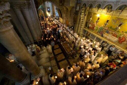 Clérigos cristãos mantêm velas durante a procissão do Domingo de Páscoa na Igreja do Santo Sepulcro, em Jerusalém, neste domingo (Foto: Reprodução)